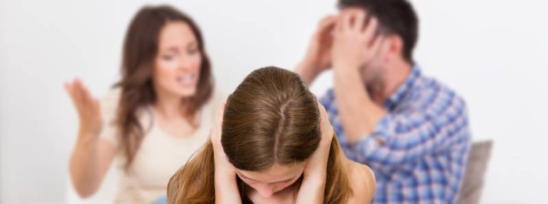 Ehestreitszene - 2 Eltern streiten, das Kind hält sich die Ohren zu
